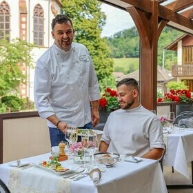 Michael Mannel serviert einem Gast im goldenen Engel eine Speise