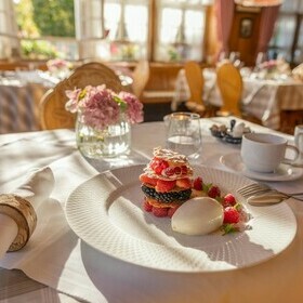 gedeckter Tisch mit stilvoller Blumendeko und Dessert im Gasthaus goldener Engel